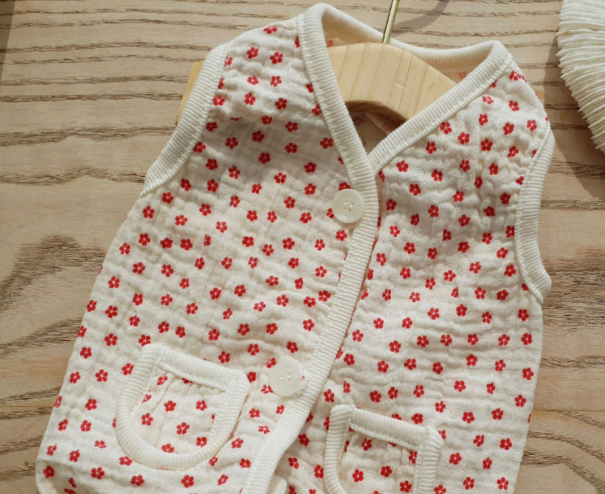 White crinkle dog vest with red floral pattern and white button details