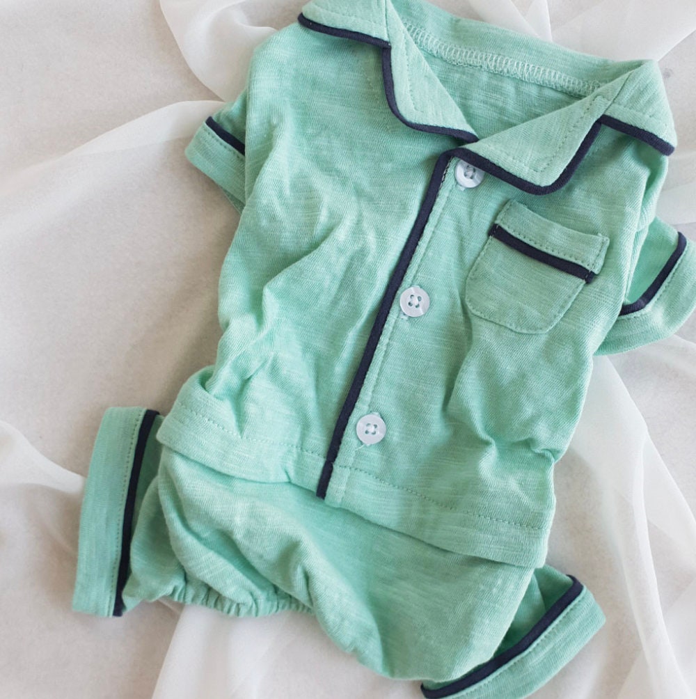 Mint green solid dog pajamas overall with navy blue trim and button front.
