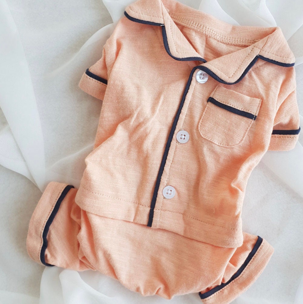 Solid peach dog pajamas overall with dark trim and button details