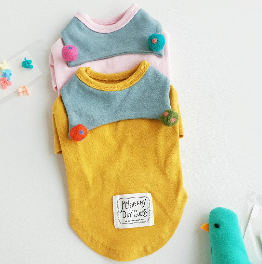 NKpup Ball Collar Dog Shirts in yellow and pink with contrasting blue chest panels and colorful pom-pom accents