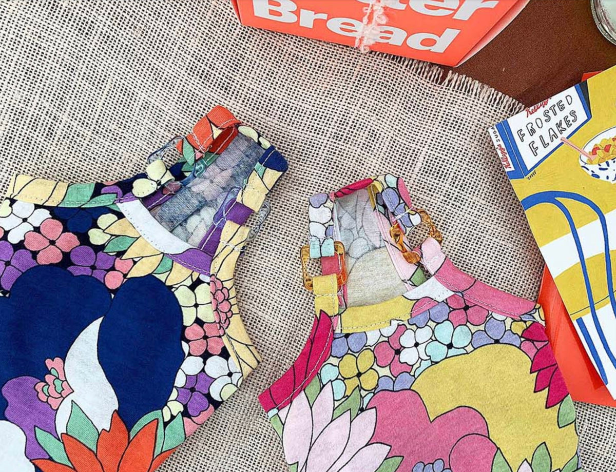 Two NKpup cotton floral dresses featuring vibrant, colorful botanical patterns.