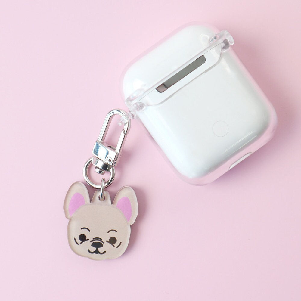 Personalized dog breed pendant keychain attached to a clear wireless earbud case.