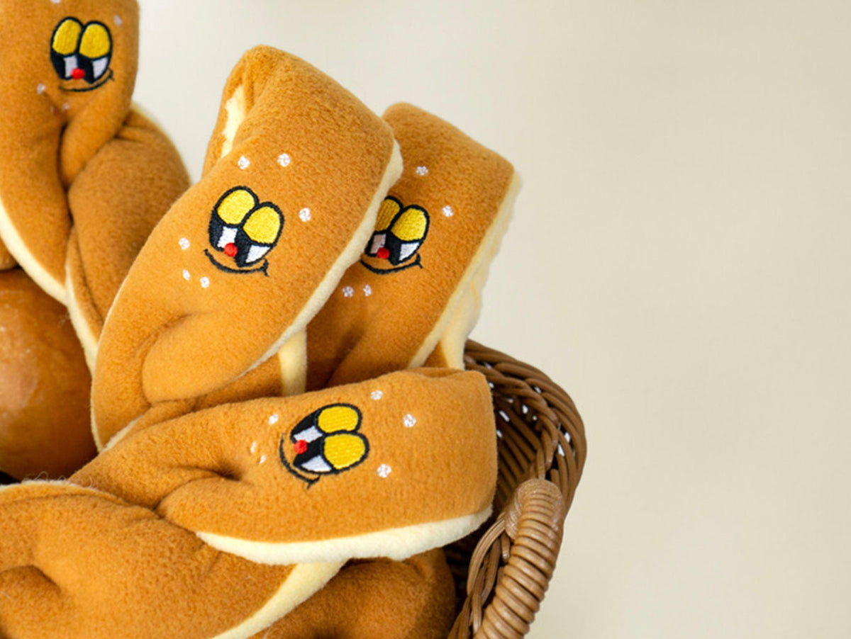 NKpup Snuffle Pretzel Dog Toy in tan with embroidered cartoon faces