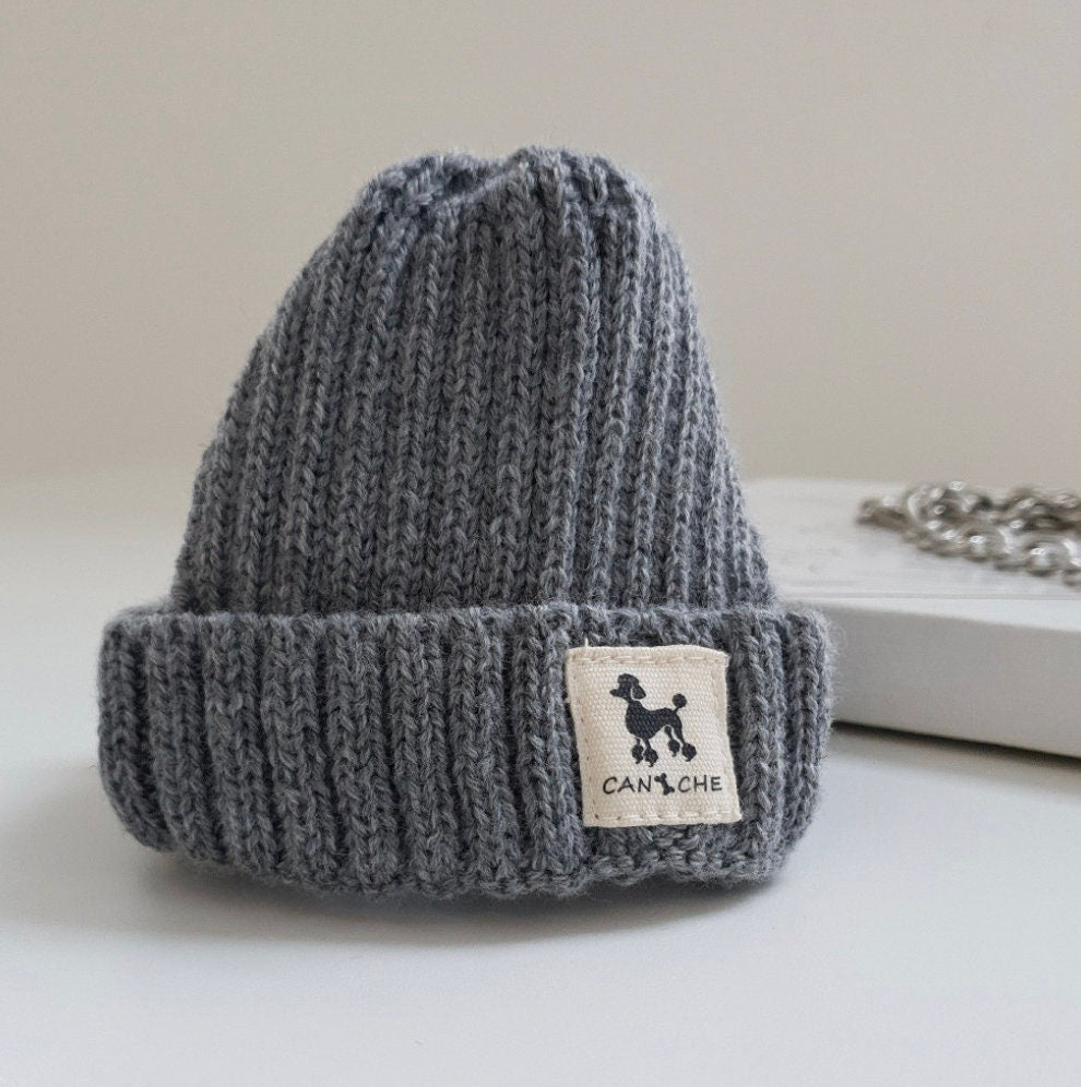 Grey ribbed cuff dog beanie with a white brand patch featuring a poodle silhouette.
