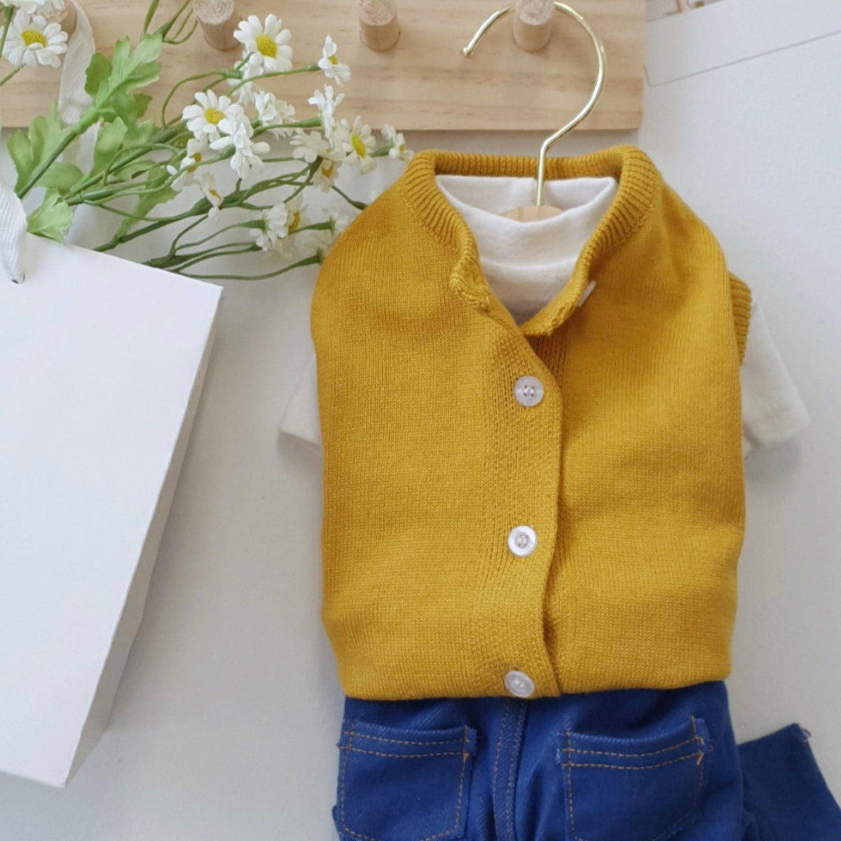 Vivid yellow knit dog cardigan vest with white buttons and a white undershirt.