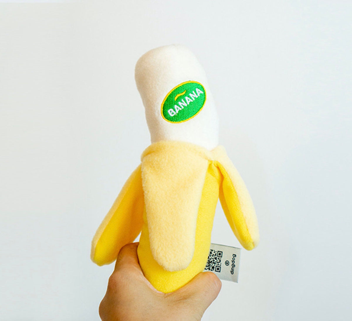 Yellow banana-shaped snuffle dog toy with a green banana patch.