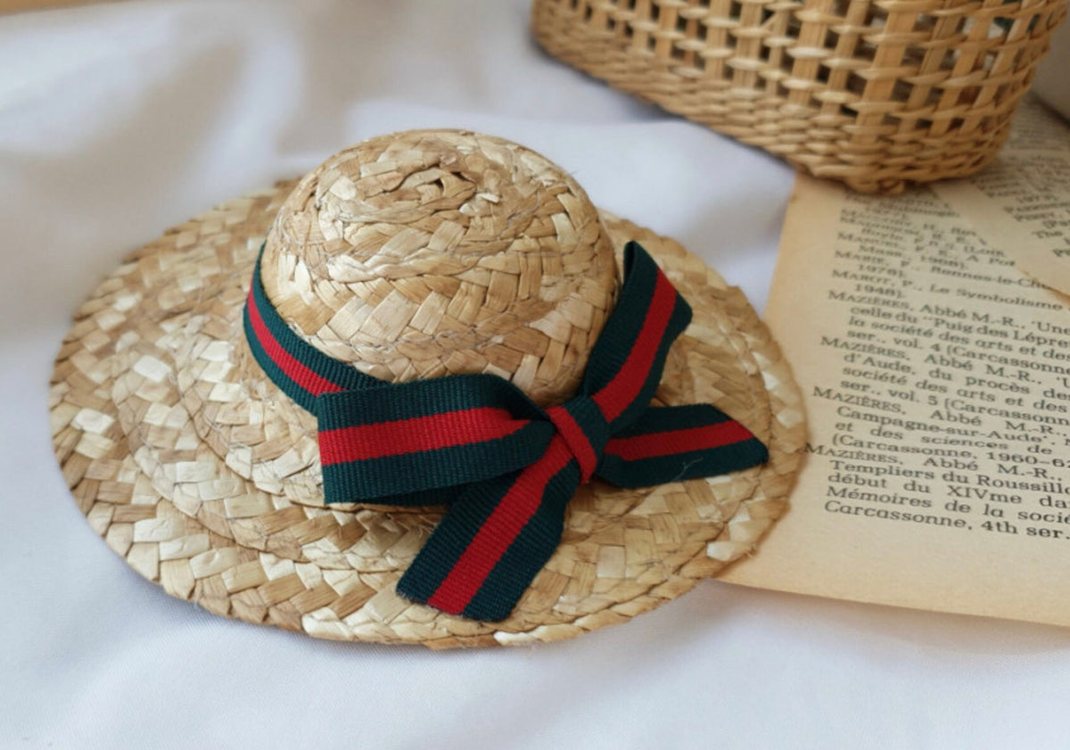 Straw ribbon dog hat with a red and green striped bow decoration by NKpup