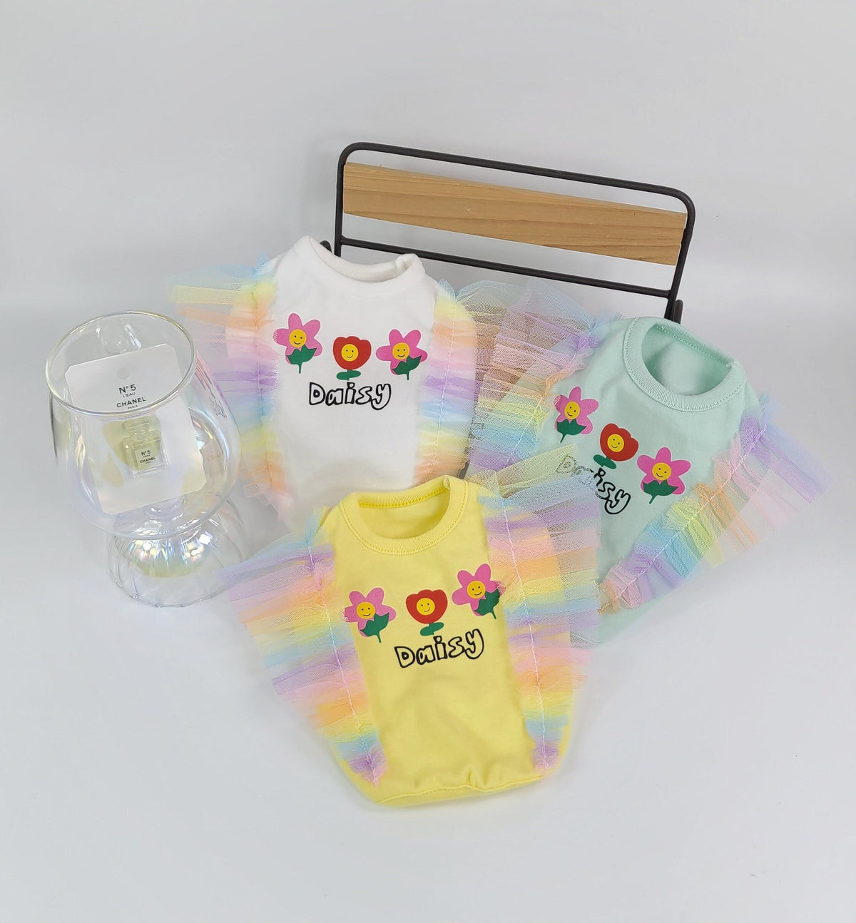 Set of three NKpup rainbow frilled crop top dog shirts in white, mint, and yellow with flower embroidery.
