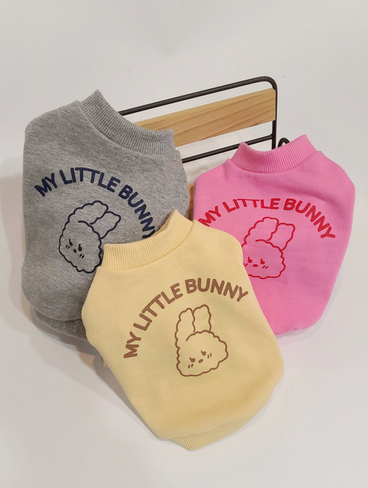 Three Wild Bunny sweatshirts for dogs in grey, pink, and yellow featuring a bunny graphic.