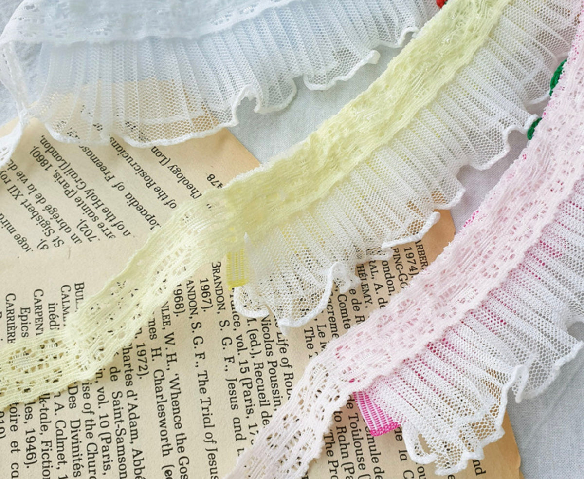 Cherry Lace Dog Cape featuring delicate white, pale yellow, and pink lace ruffles.