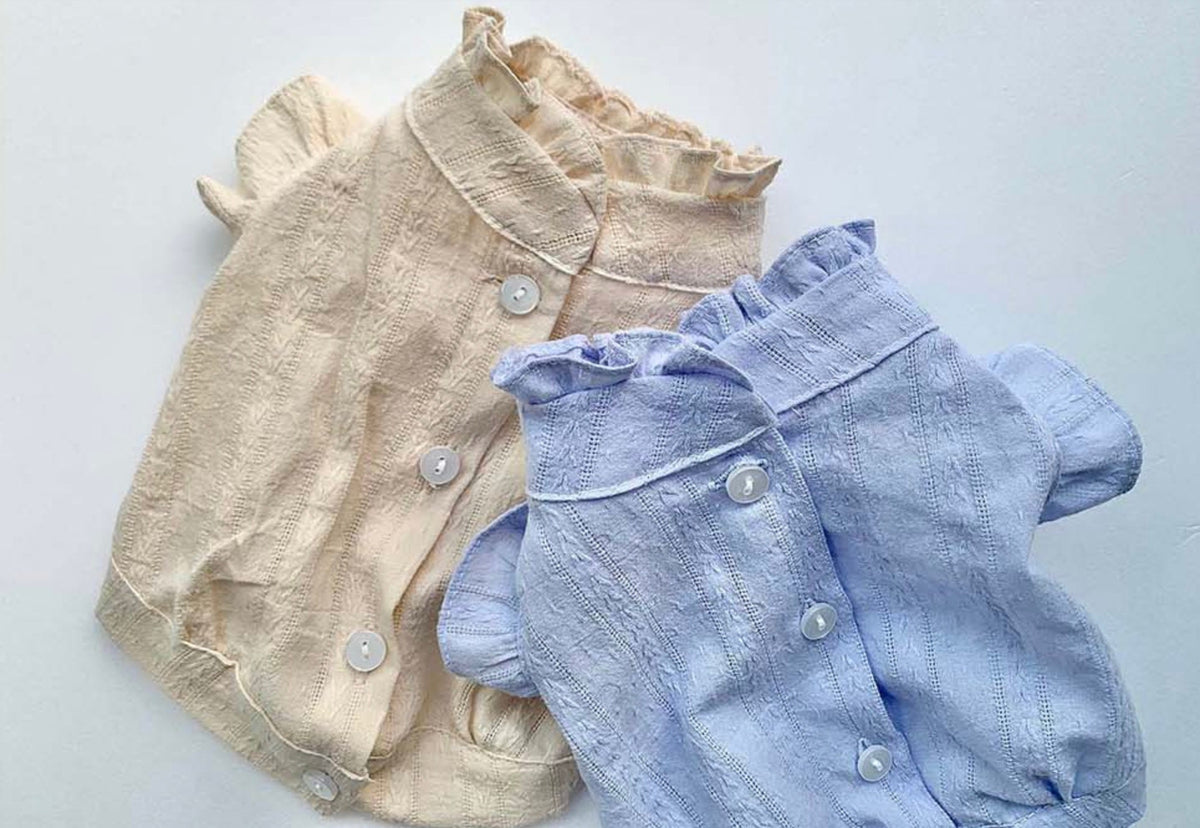 NKpup frilled blouses for dogs in beige and light blue with button-down fronts.