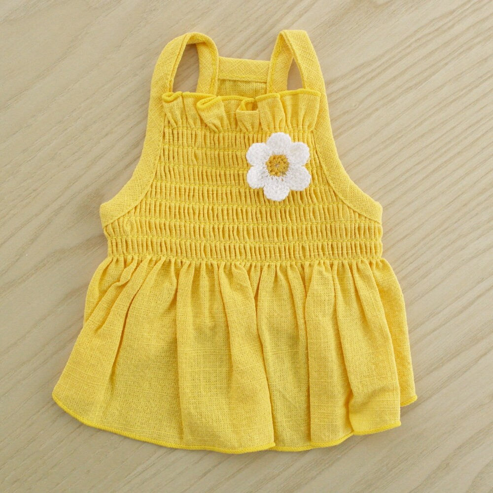 Yellow linen smocked dog dress with a white daisy flower detail.