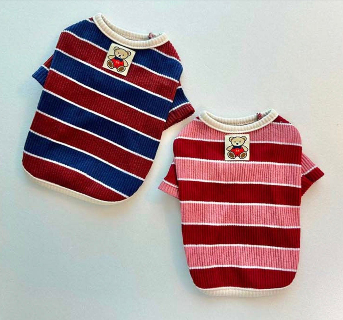 Two NKpup Joy Striped Dog T-Shirts, one in navy and red stripes and one in pink and red stripes.