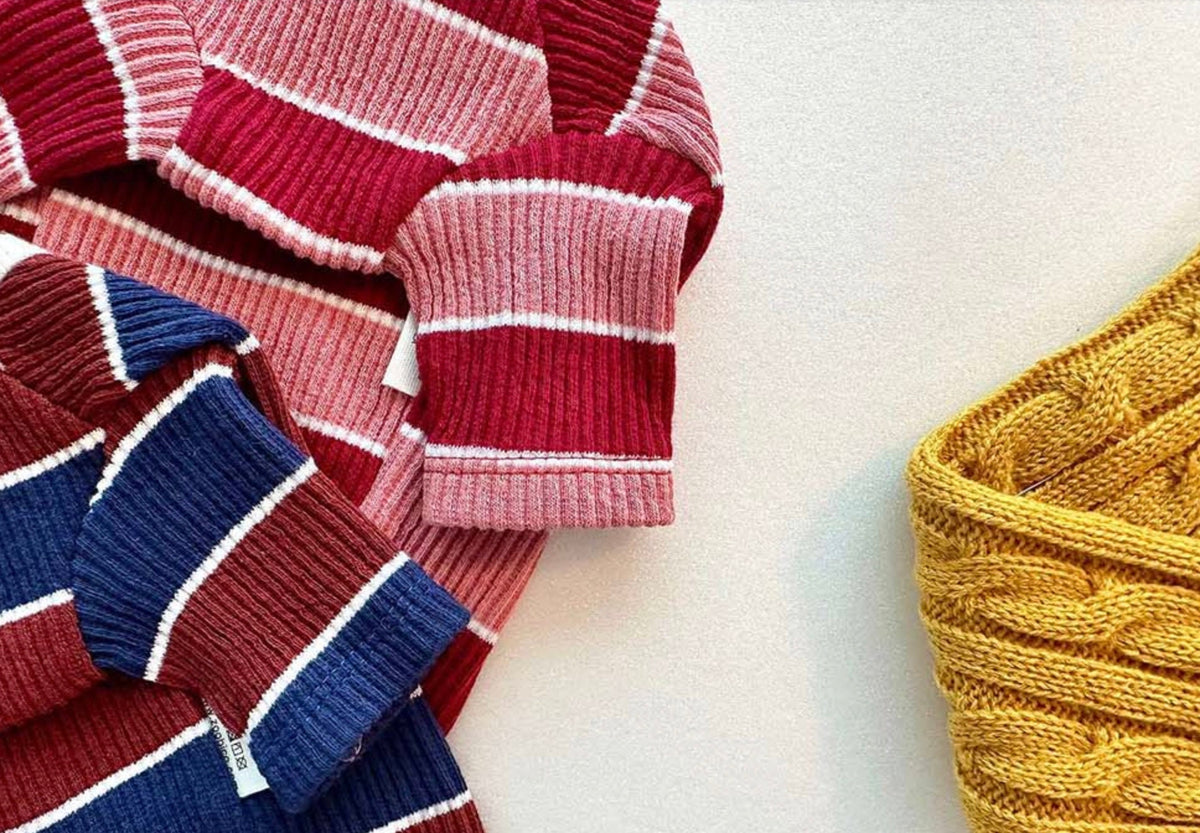 NKpup Joy Striped Dog T-Shirt in pink, red, blue, and mustard yellow ribbed knit patterns.