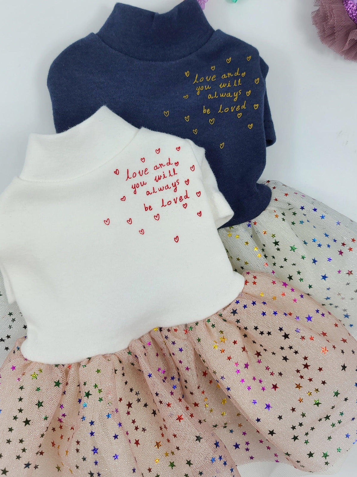 White and navy blue Halloween dog tutu dresses with embroidered heart text and star-patterned tulle skirts.