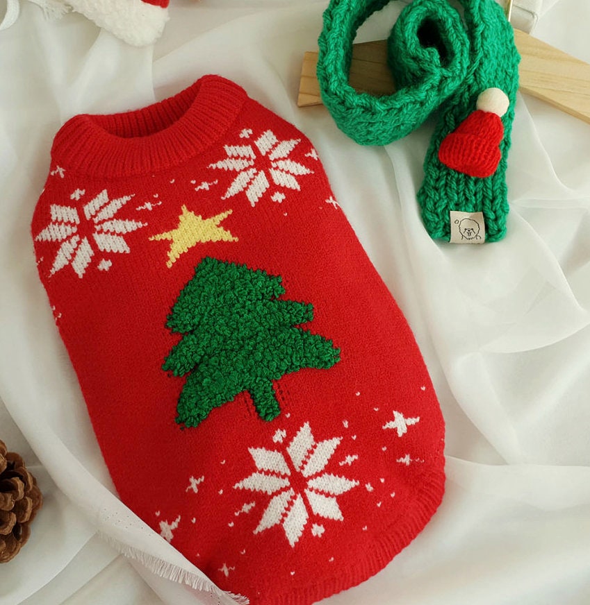 Red handmade knit dog sweater with a green Christmas tree and white snowflake pattern
