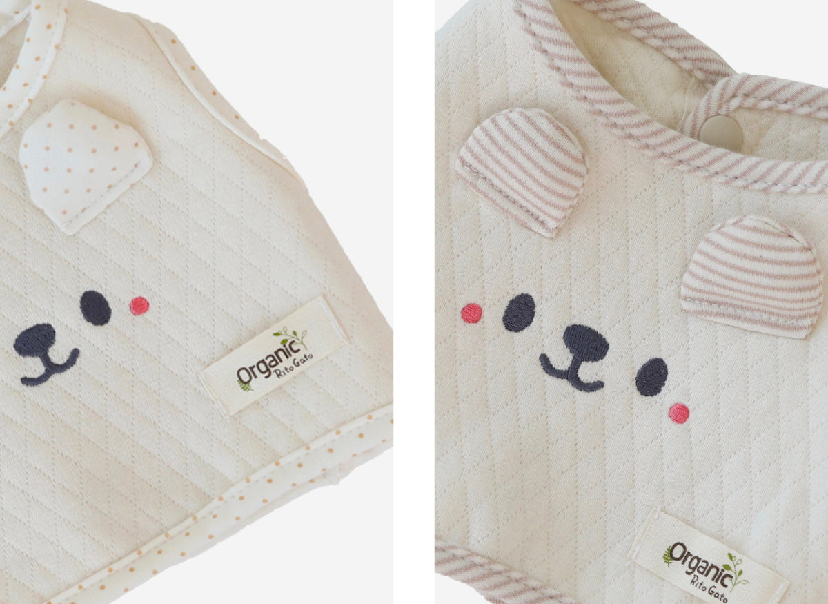 Cream organic quilted dog crop vest with cute bear face embroidery and polka dot details.