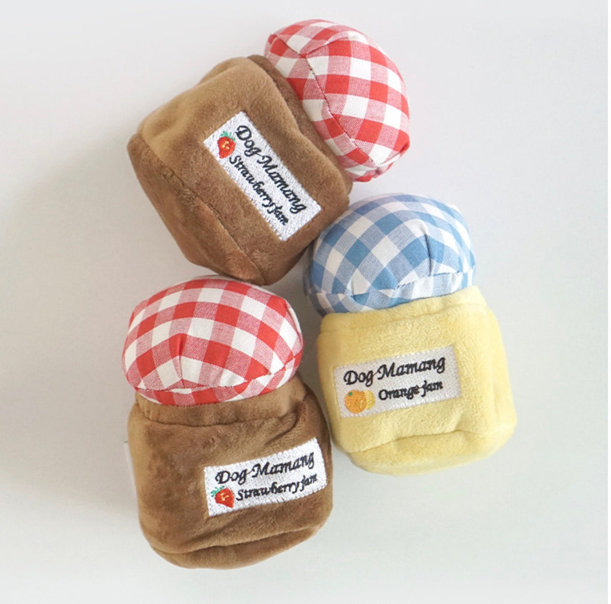 Three Snuffle Jam dog toys shaped like jam jars in strawberry and orange flavors.
