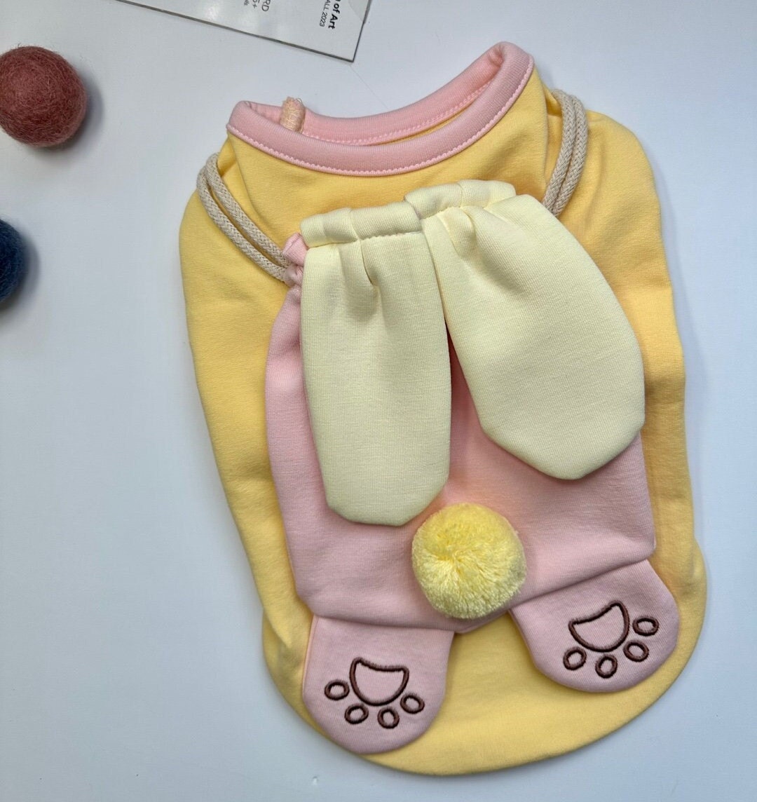 Yellow Bunny Bag dog shirt with pink bunny ear details and a yellow pompom