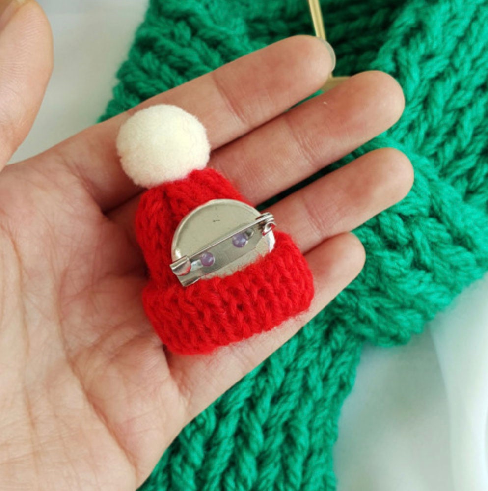 Red handmade knit Christmas dog scarf with a white pom-pom detail.
