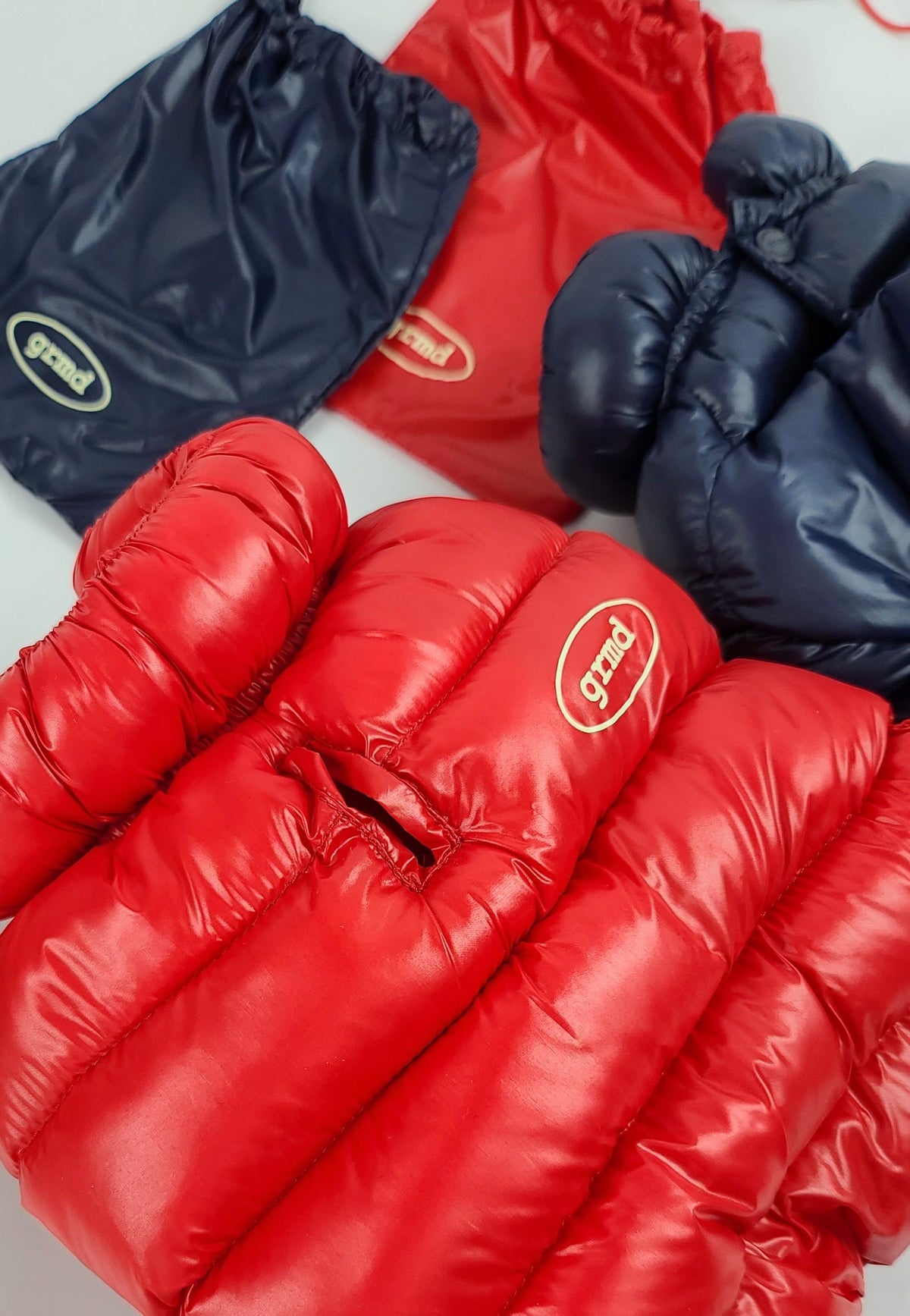 Red and navy blue lightweight padded dog overalls with grnd logo patches.